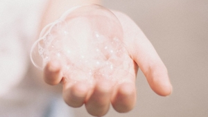 Outstretched hand holding bubbles